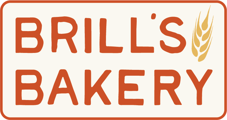 Brill's Bakery badge — hand-lettered rust-red wordmark with a gold wheat sprig on a cream label